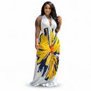 Woman in a white dress with yellow and blue abstract pattern walking on a sidewalk.
