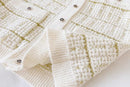 Close-up of a textured white fabric with gold accents on a white background