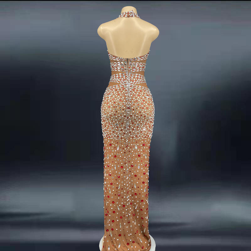 Elegant evening gown with red and gold sequins on a mannequin against a dark background