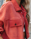 Close-up of a person wearing a red fleece jacket with a blurred background