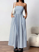 Woman wearing a blue and white striped dress with a white background