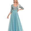 Woman wearing a blue dress with a sequined top in an elegant room.