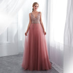 Woman wearing a pink evening gown with a beaded top in a bright room.