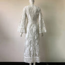 White lace dress on a mannequin against a plain background
