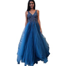 Woman in a blue evening gown standing on steps outside a building