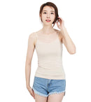 Woman wearing a beige tank top and denim shorts against a white background